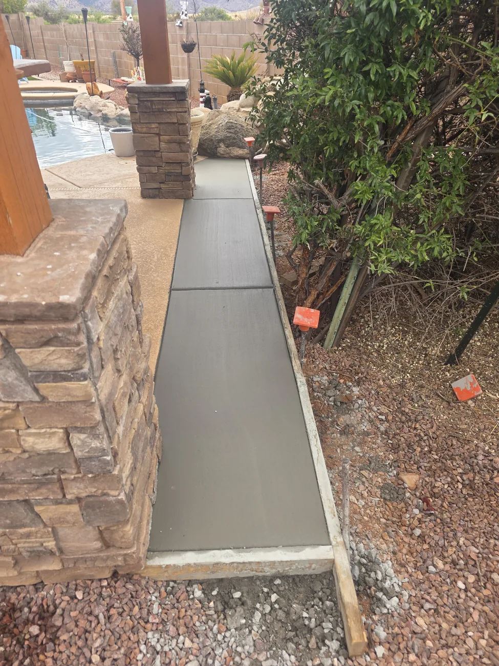 Concrete walkway with stone column and wall